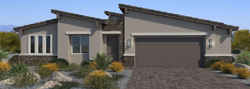 view of front of property with an attached garage, stone siding, decorative driveway, and stucco siding