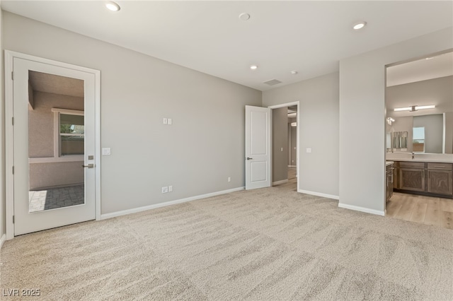 6312 Zephyr Ct, Las Vegas, NV 89149 - unfurnished bedroom featuring light carpet, baseboards, ensuite bathroom, a sink, and recessed lighting