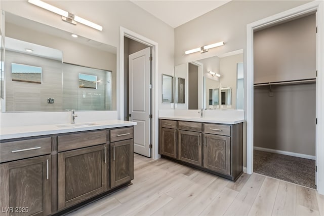 6312 Zephyr Ct, Las Vegas, NV 89149 - bathroom featuring two vanities, wood finished floors, and tiled shower