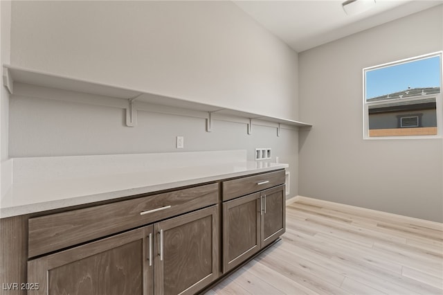 6312 Zephyr Ct, Las Vegas, NV 89149 - laundry area with washer hookup, light wood finished floors, baseboards, and cabinet space