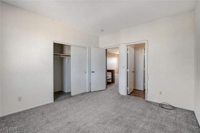 unfurnished bedroom with a closet, carpet, and baseboards