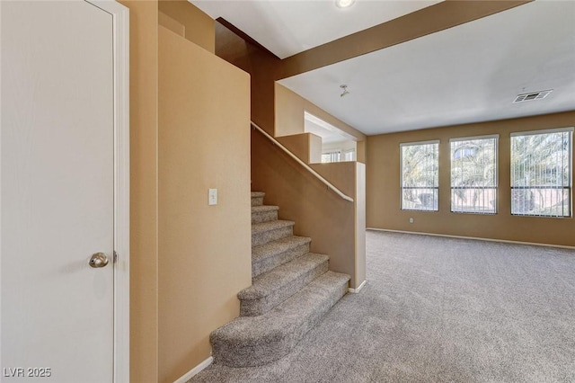 stairs featuring baseboards, visible vents, and carpet flooring