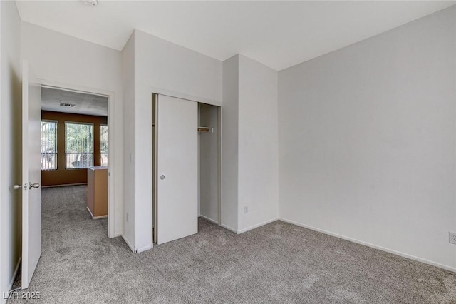 unfurnished bedroom with carpet floors, baseboards, and a closet