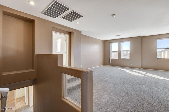 carpeted empty room featuring recessed lighting, visible vents, and baseboards