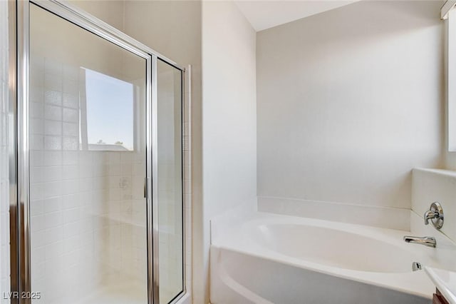 bathroom with a garden tub and a shower stall