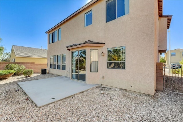 rear view of property with a patio area, fence, and stucco siding