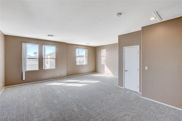 spare room with carpet, visible vents, and baseboards