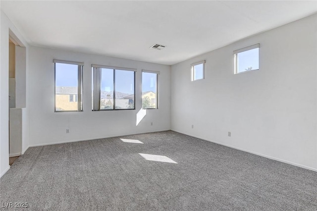 carpeted empty room with visible vents and baseboards