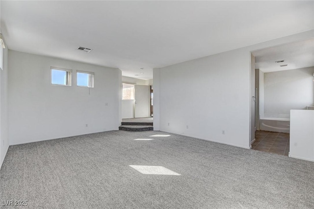 empty room featuring carpet floors and visible vents