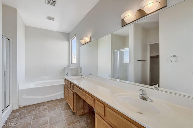 full bathroom with visible vents, a sink, a shower stall, and a garden tub