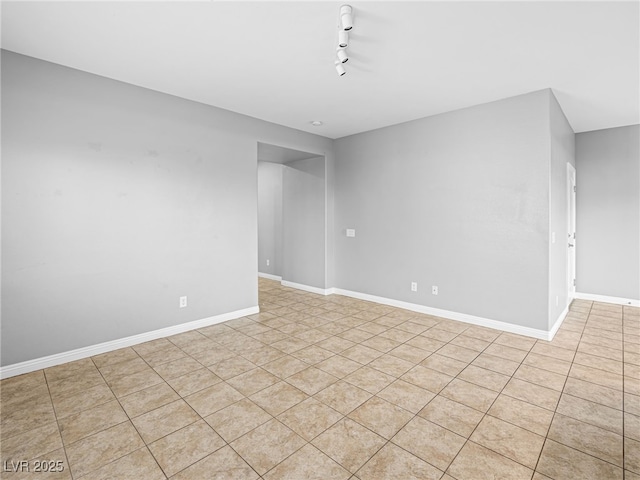 unfurnished room with baseboards