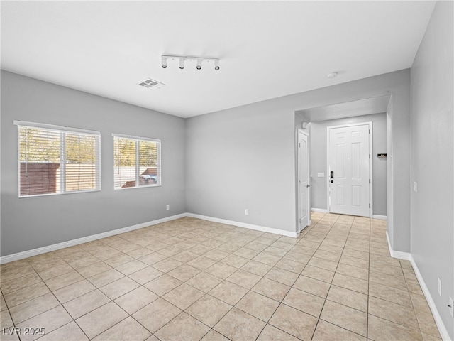 empty room with baseboards and visible vents