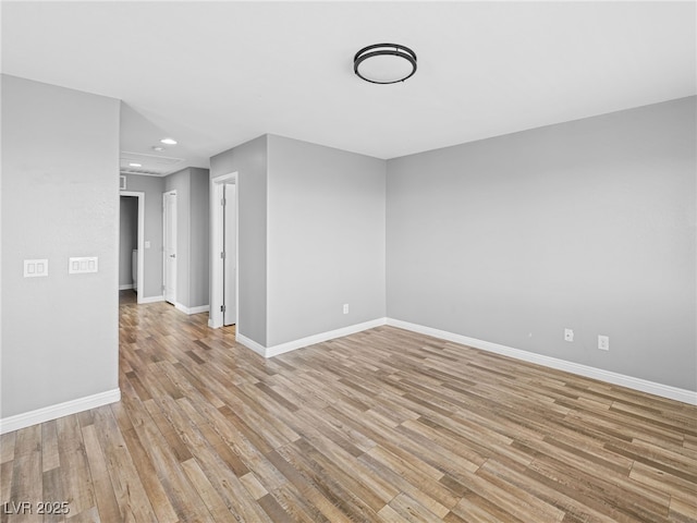 empty room featuring recessed lighting, light wood-type flooring, and baseboards