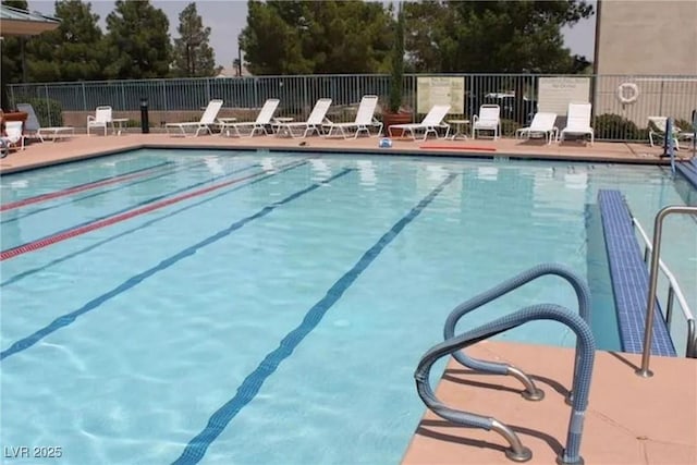 community pool with a patio area and fence