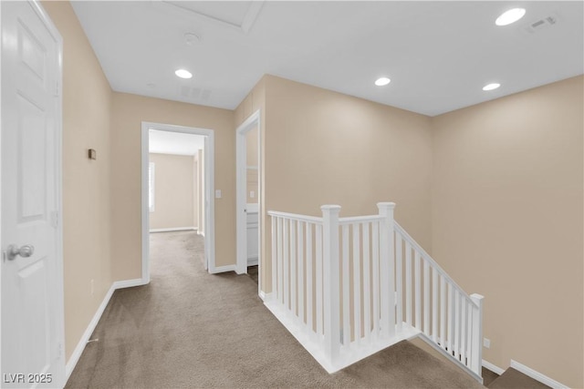 corridor featuring carpet floors, recessed lighting, baseboards, and an upstairs landing