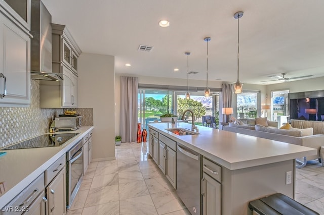 kitchen with visible vents, appliances with stainless steel finishes, marble finish floor, wall chimney range hood, and a sink