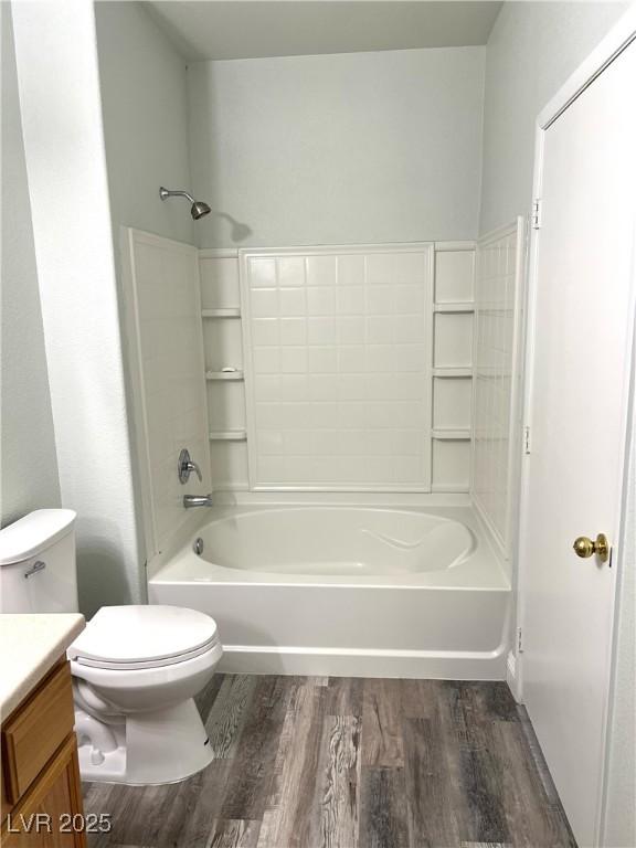 bathroom featuring shower / tub combination, vanity, toilet, and wood finished floors