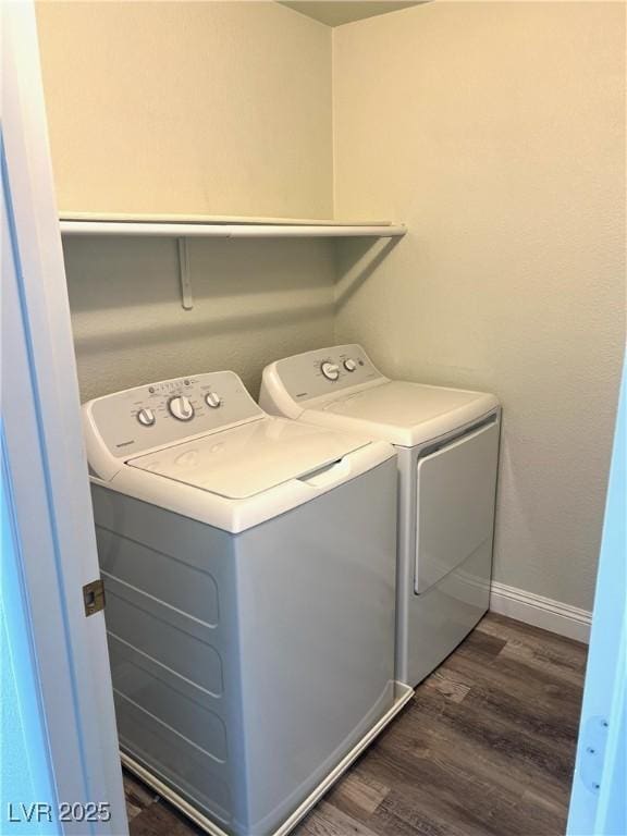 washroom featuring baseboards, laundry area, dark wood-type flooring, and washer and dryer