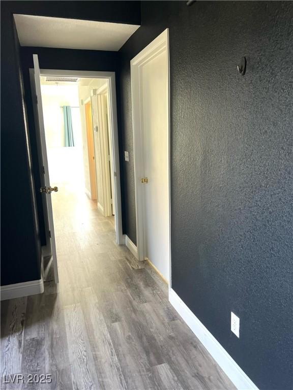 hallway with baseboards and wood finished floors