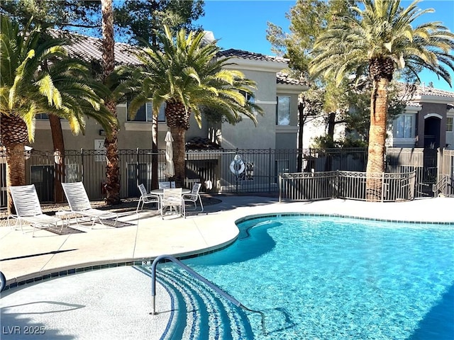 community pool featuring a patio and fence