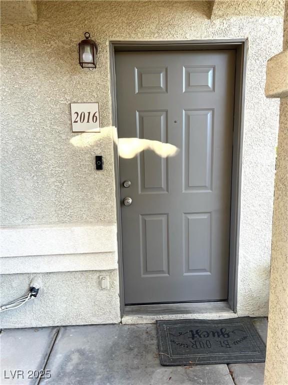 entrance to property featuring stucco siding