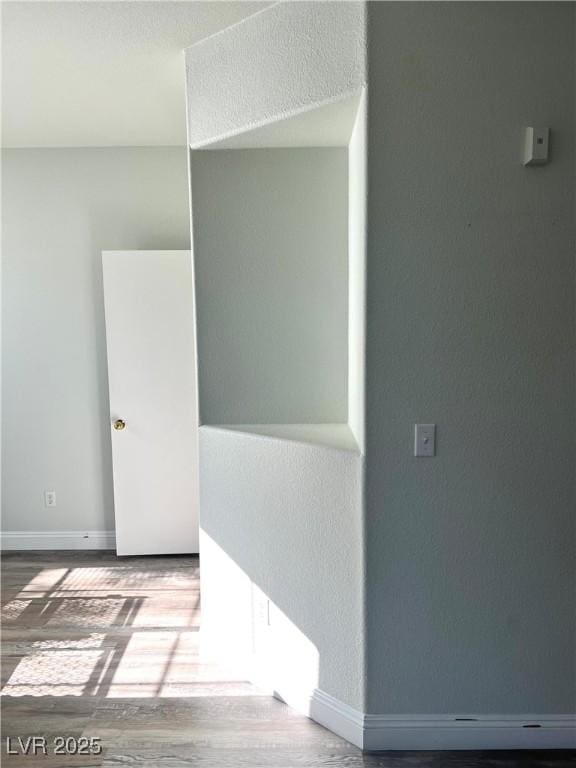 unfurnished room with baseboards and wood finished floors