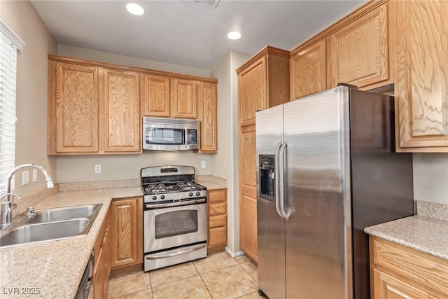 kitchen featuring light tile patterned floors, recessed lighting, stainless steel appliances, a sink, and light stone countertops