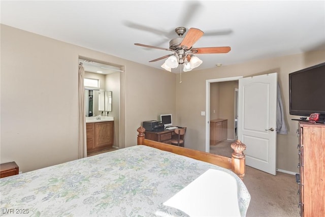 bedroom with light carpet, a sink, ceiling fan, ensuite bath, and baseboards