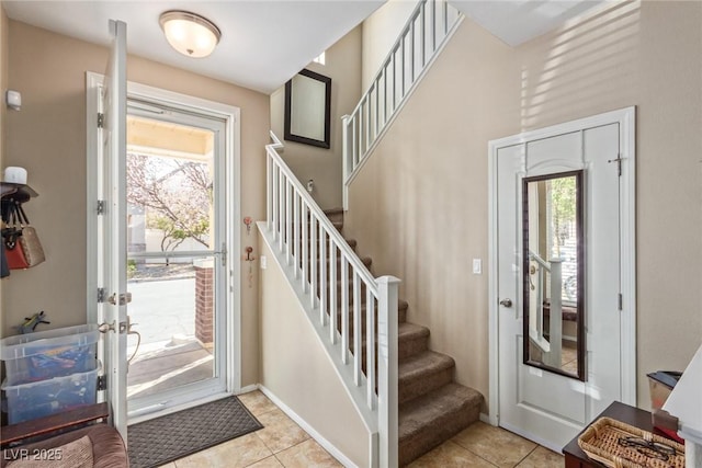 entryway with light tile patterned floors and stairs