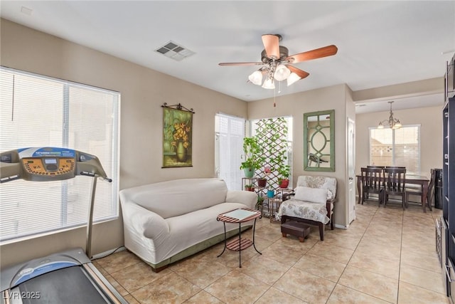 interior space with light tile patterned floors, visible vents, and ceiling fan with notable chandelier