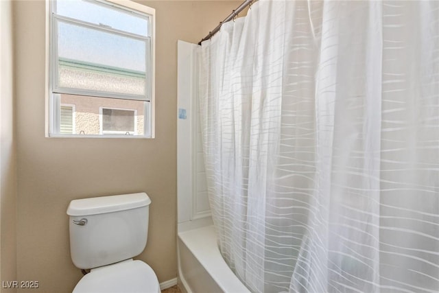 bathroom with toilet and shower / bath combo with shower curtain