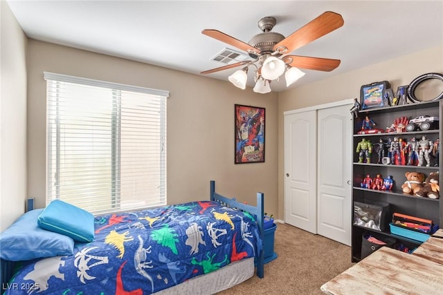 bedroom with carpet floors, a closet, visible vents, and a ceiling fan