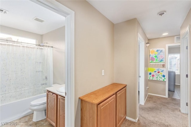 bathroom featuring toilet, a wealth of natural light, vanity, and shower / tub combo with curtain