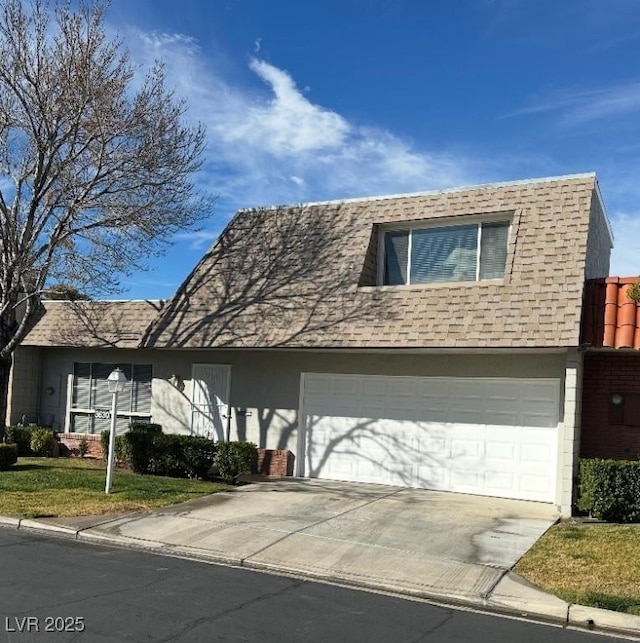 view of front facade with a garage, driveway, and stucco siding