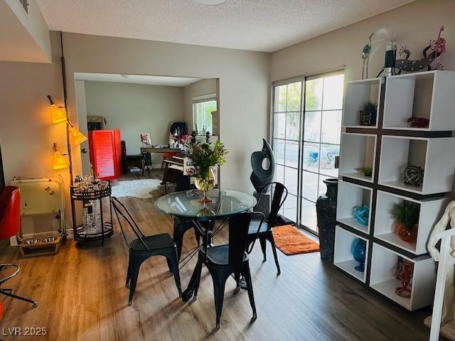 dining room with a textured ceiling and wood finished floors