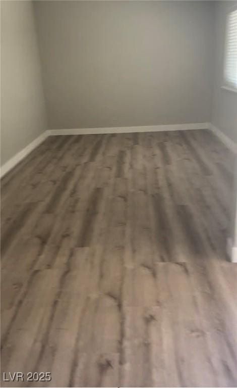 unfurnished room with baseboards and wood finished floors