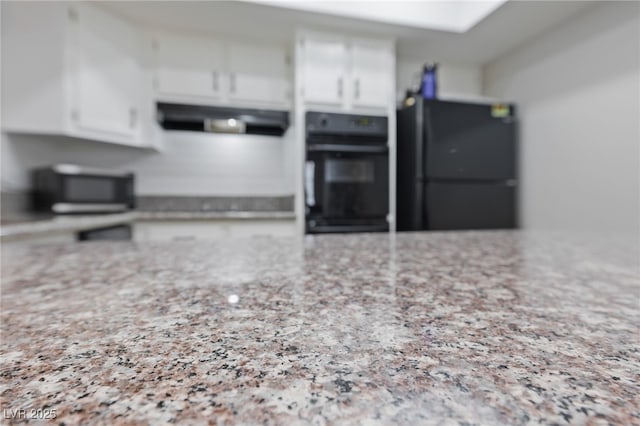 kitchen featuring black appliances, white cabinets, speckled floor, light stone countertops, and extractor fan