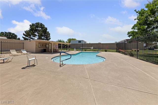 pool with a patio area and fence