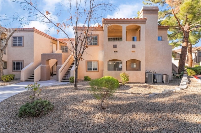 view of property featuring central AC unit and stairway