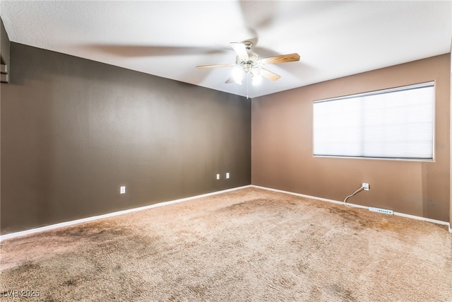 spare room with a ceiling fan, carpet flooring, and baseboards