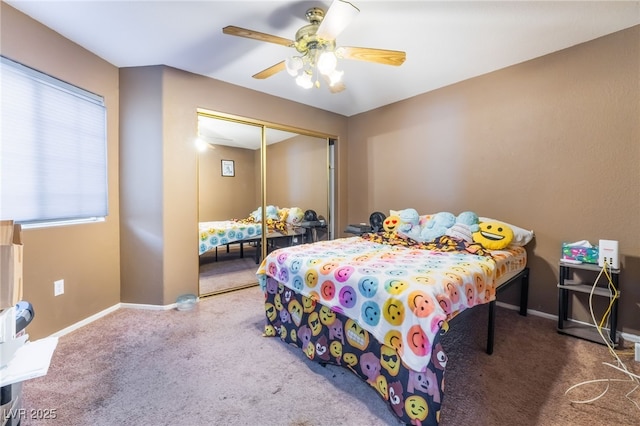 carpeted bedroom with ceiling fan, baseboards, and a closet