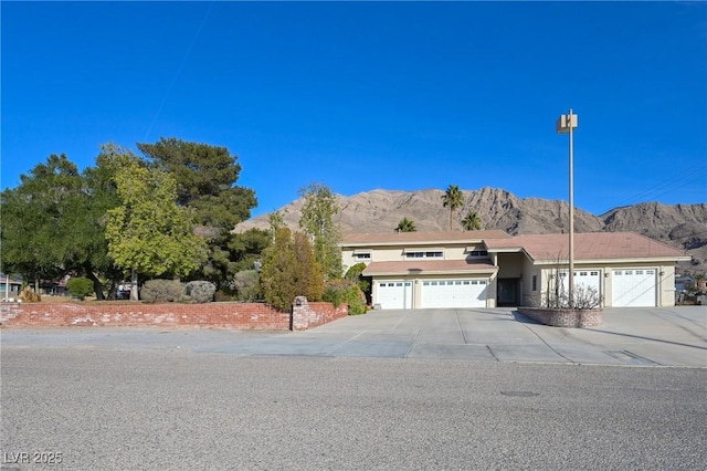 view of front of home featuring a mountain view, driveway, and an attached garage