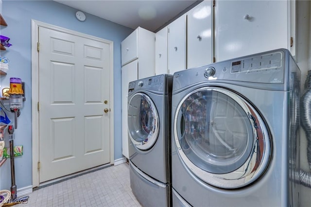 laundry area with light tile patterned floors, cabinet space, and separate washer and dryer