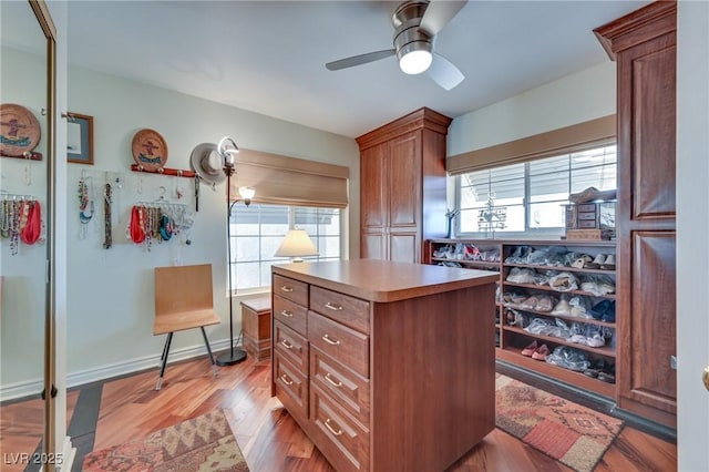 walk in closet featuring ceiling fan and light wood-type flooring