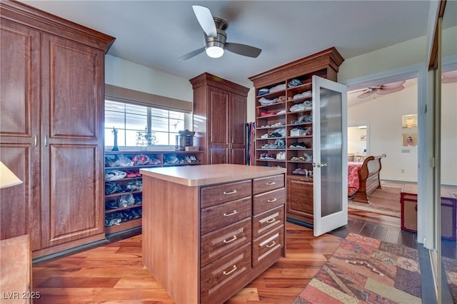 walk in closet featuring ceiling fan and light wood-style floors