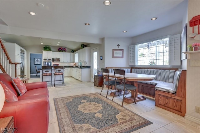 living room with light tile patterned floors, lofted ceiling, recessed lighting, stairs, and breakfast area