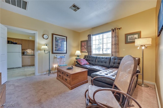 living area with light carpet, baseboards, and visible vents