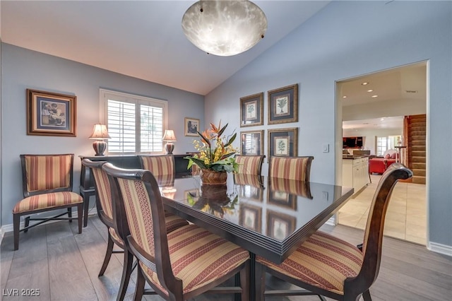 dining area with lofted ceiling, wood finished floors, and baseboards