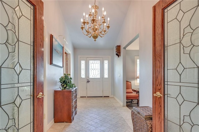 entrance foyer with light tile patterned floors, vaulted ceiling, an inviting chandelier, and baseboards