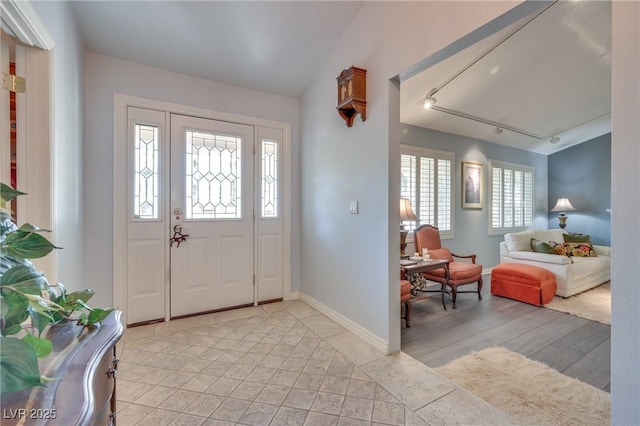 foyer entrance with track lighting and baseboards